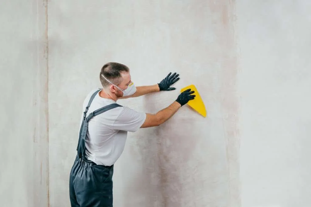 A MAN IS Applying wall stickers in bedroom