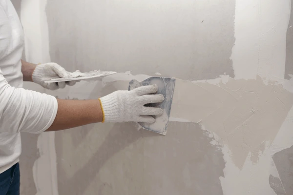 a man patching a damaged wall