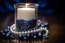 A candle with blue beads and a white candle in the middle