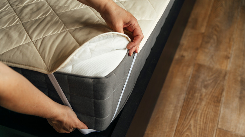 a man covering the mattress with protector